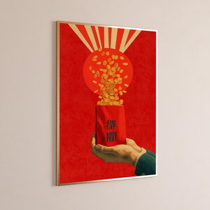 May include: A framed vertical poster featuring a red background with a large orange circle and radiating light beams. A hand holds a red envelope with black Chinese characters, from which a cascade of gold coins flows upward into the circle.