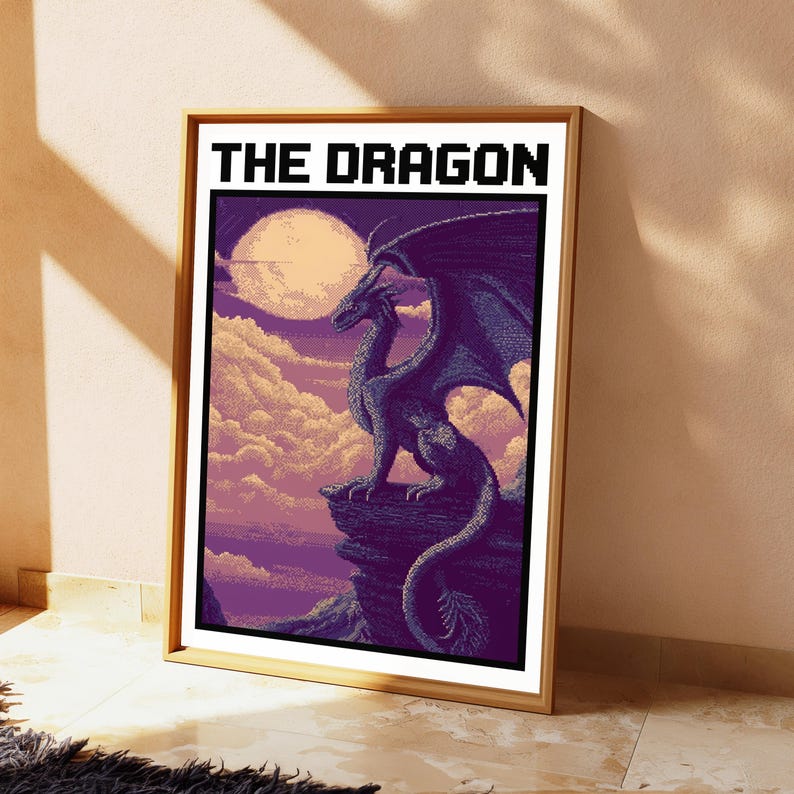 May include: A framed pixel art print titled THE DRAGON, featuring a dark purple dragon perched on a rocky cliff edge against a backdrop of a large pale moon, soft clouds, and a purple sky. The artwork uses a distinct blocky digital aesthetic.