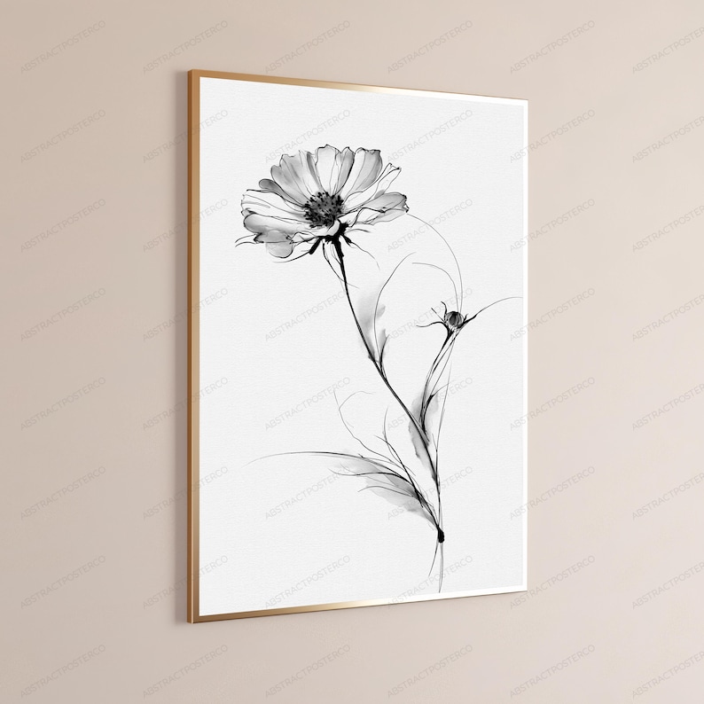 May include: A framed wall art print featuring a black and white botanical illustration of a single cosmos flower with delicate, wispy petals and a slender stem. The artwork is presented in a thin, metallic gold frame against a neutral wall.