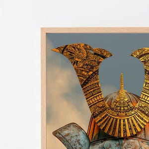 May include: A framed wall art print featuring a detailed golden samurai helmet with intricate embossed patterns and a weathered blue metal base, set against a soft, cloudy sky background. The helmet displays a prominent central spike.