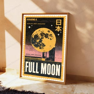 May include: A rectangular poster in a wooden frame featuring a vintage postage stamp design. The artwork displays a large yellow full moon against a black starry sky, with the text ISSUE NO. 5, WORLDS BEST MAGAZINE, and FULL MOON in white.