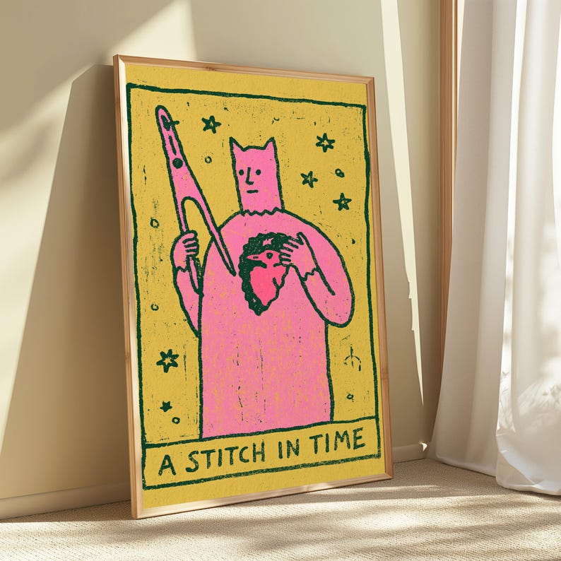 Puede incluir: Una impresi&oacute;n rectangular enmarcada que muestra una figura rosa con orejas puntiagudas sosteniendo una aguja grande y un p&aacute;jaro peque&ntilde;o sobre un fondo amarillo. La obra incluye contornos verde oscuro, estrellas y el texto A STITCH IN TIME.