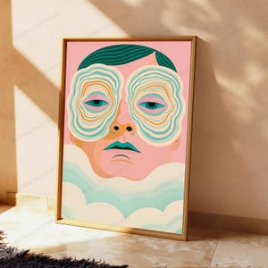 May include: A framed vertical art print featuring a stylized human face with dark teal hair. The eyes are surrounded by concentric, wavy rings in shades of teal, orange, and cream. The lips are teal, and the lower portion of the face is obscured by soft, pale blue and cream cloud-like shapes against a solid pink background.
