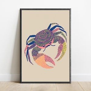 May include: A framed wall art print featuring a stylized crab illustration on a beige background. The crab is rendered with dark blue, pink, and yellow patterns, including dots and lines, set within a simple black frame for a clean display.