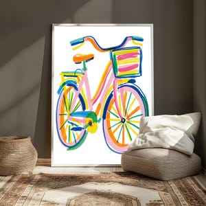 May include: A framed art print featuring a colorful, painterly illustration of a bicycle. The bicycle is rendered in vibrant brushstrokes of pink, orange, yellow, blue, and green, complete with a front basket and a rear rack on a white background.