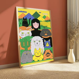 May include: A framed rectangular wall art print featuring a colourful illustration of a person with black hair surrounded by various cats and dogs. The background depicts stylised mountains, green hills, and a cactus under a bright yellow sky.
