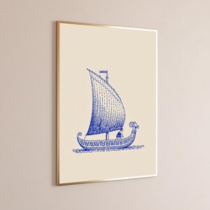 May include: A framed wall art print featuring a blue line drawing of an ancient sailing vessel on a cream background. The ship displays a Greek key pattern along the hull, a single large sail, and a figure standing on the deck of the boat.
