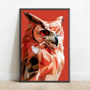 Op de afbeelding: Een ingelijste wandkunstprint met een geometrische uilenillustratie in low-poly-stijl. De uil is weergegeven in tinten oranje, bruin en wit, met een opvallend rood oog, tegen een effen, levendige oranje achtergrond in een zwarte lijst.