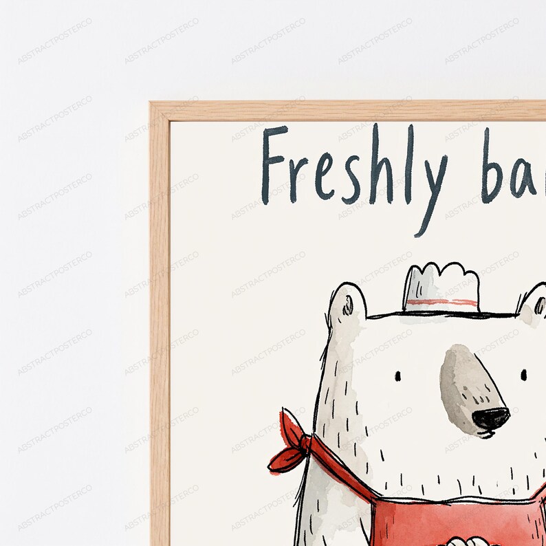 Puede incluir: Una impresi&oacute;n art&iacute;stica enmarcada que muestra un oso blanco con un delantal rojo y un gorro de chef. El oso lleva un pa&ntilde;uelo rojo alrededor del cuello. El texto Freshly ba est&aacute; impreso en azul oscuro sobre el fondo blanco roto. El marco es de madera clara.