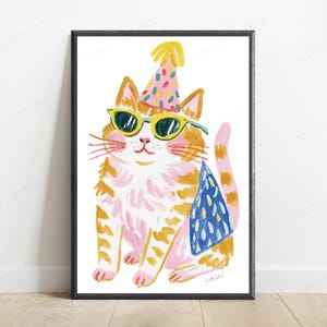 K&ouml;nnte beinhalten: Ein gerahmter Kunstdruck, der eine gemalte orangefarbene getigerte Katze mit einem rosa Partyhut mit bunten Konfettipunkten und einer gelb umrandeten Sonnenbrille zeigt. Die Katze tr&auml;gt einen blau gemusterten Umhang auf dem R&uuml;cken.