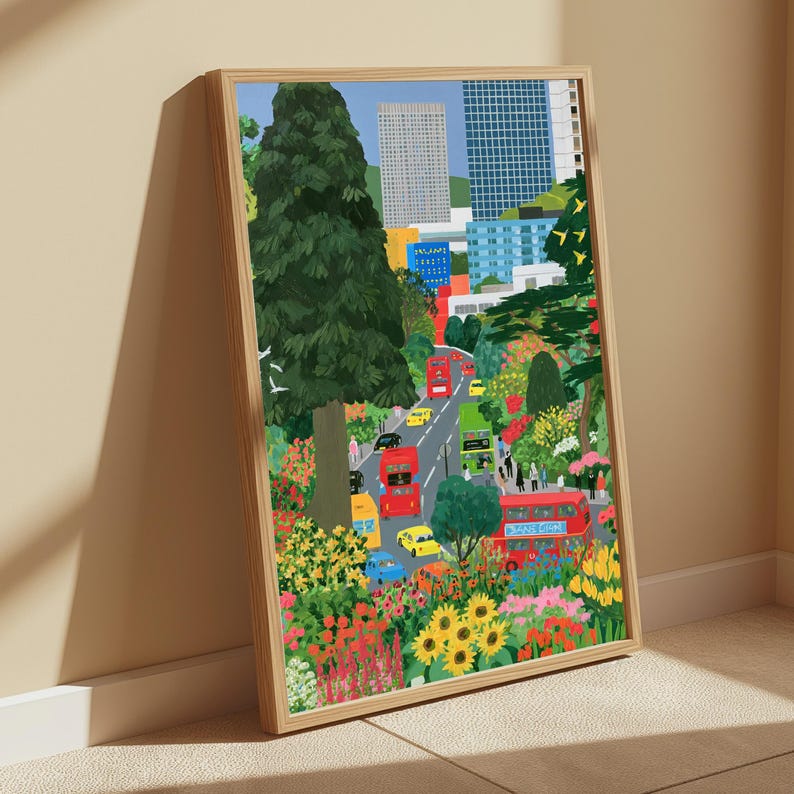 May include: A framed vertical art print depicting a city street scene with red double-decker buses, yellow taxis, and blue cars surrounded by lush green trees and vibrant flowers, set against a backdrop of tall modern skyscrapers and buildings.