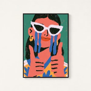 May include: A framed art print featuring a stylized illustration of a person with dark hair wearing white cat-eye sunglasses. The person has blue tears streaming down their face, is wearing a yellow patterned shirt, and is giving two thumbs up.