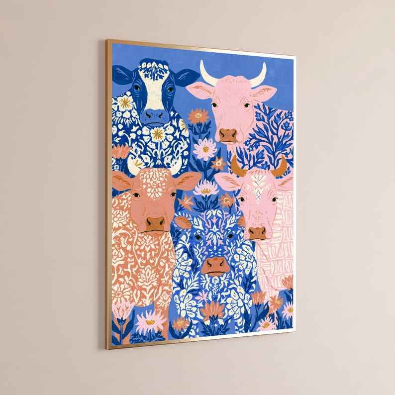 May include: A framed wall art print featuring four cows in various colours including blue, pink, and peach, each decorated with intricate white floral patterns. The cows are positioned against a solid blue background with small pink and orange flowers.