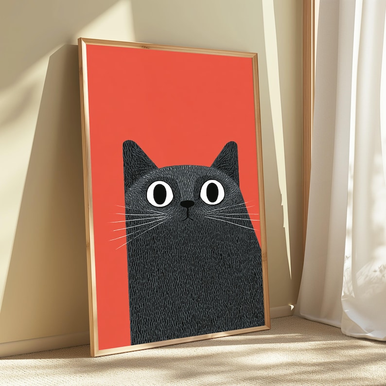 May include: A rectangular framed wall art print featuring a stylized illustration of a black cat with large white eyes and long white whiskers set against a solid vibrant orange background. The cat has a textured appearance and a neutral expression.
