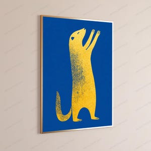 K&ouml;nnte beinhalten: Ein gerahmter vertikaler Wandkunstdruck, der ein stilisiertes gelbes Erdm&auml;nnchen zeigt, das auf seinen Hinterbeinen steht und die Arme vor einem einfarbigen, tiefblauen Hintergrund hebt. Das Erdm&auml;nnchen hat eine k&ouml;rnige Textur und einen geschwungenen Schwanz.