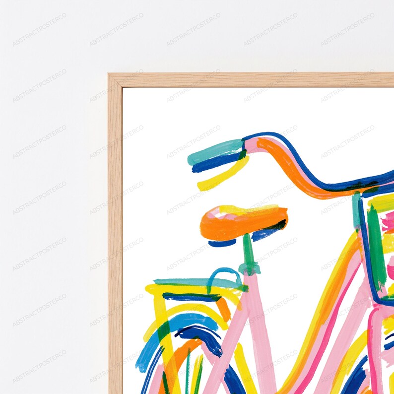 May include: A framed wall art print featuring a stylized, abstract bicycle illustration. The artwork uses bold, expressive brushstrokes in vibrant colors including orange, pink, yellow, blue, and green against a clean white background.