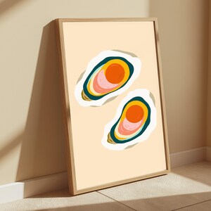 K&ouml;nnte beinhalten: Ein gerahmter vertikaler Wandkunstdruck mit zwei stilisierten Austernillustrationen auf hellbeigem Hintergrund. Jede Auster ist mit einem wei&szlig;en Schalenrand, einem dunkelblauen Rand und einem zentralen kreisf&ouml;rmigen Design in Orange und Rosa dargestellt.