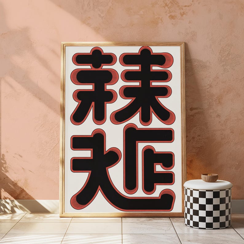 May include: A rectangular framed wall art print featuring large, bold black Chinese characters with a red outline and shadow effect on a white background. The artwork is displayed in a light-coloured wooden frame, showcasing a graphic design style.