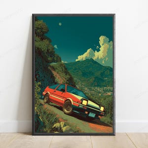 May include: A framed vertical art print featuring a red and white sports car driving on a winding mountain road. The scene includes lush green hills, a distant town, and a deep teal sky with clouds. The car has pop-up headlights and dark wheels.