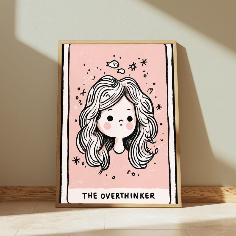 May include: A framed rectangular wall art print featuring a light pink background with a black line drawing of a person with wavy hair. Above the head are small fish and star icons. The text THE OVERTHINKER is printed in black at the bottom.