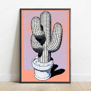Könnte beinhalten: Ein gerahmter Wandkunstdruck mit einer verpixelten Illustration eines Saguaro-Kaktus in einem Topf. Der Kaktus ist in Schwarz-Weiß mit punktierter Schattierung dargestellt, vor einem hellblauen Gittermuster auf pfirsichfarbenem Grund.