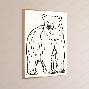 K&ouml;nnte beinhalten: Ein gerahmter Wandkunstdruck mit einer schwarzen Strichzeichnung eines stehenden B&auml;ren auf wei&szlig;em Hintergrund. Der B&auml;r ist im Profil dargestellt, wobei sein Kopf zum Betrachter gedreht ist, was einfache, klare Umrisse zur Geltung bringt.