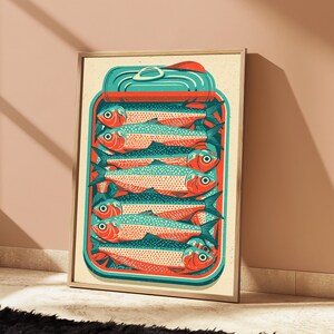 May include: A framed art print featuring a stylized illustration of a rectangular tin filled with stacked sardines. The fish are rendered in shades of orange and teal with dotted patterns. The tin has a teal lid and a red border on a cream background.