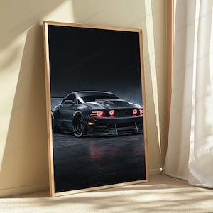 May include: A framed vertical wall art print featuring a matte black sports car with wide fenders and a large rear wing. The vehicle is positioned on a dark surface, showcasing glowing red circular headlights and a low-profile front bumper design.