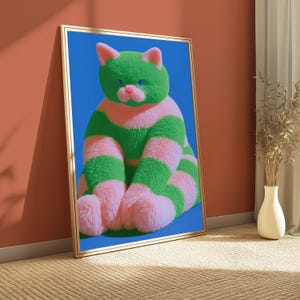 May include: A framed wall art print featuring a fluffy, textured cat with horizontal stripes of bright green and soft pink fur. The cat has small pink ears, a pink nose, and piercing blue eyes, set against a solid, vibrant blue background.
