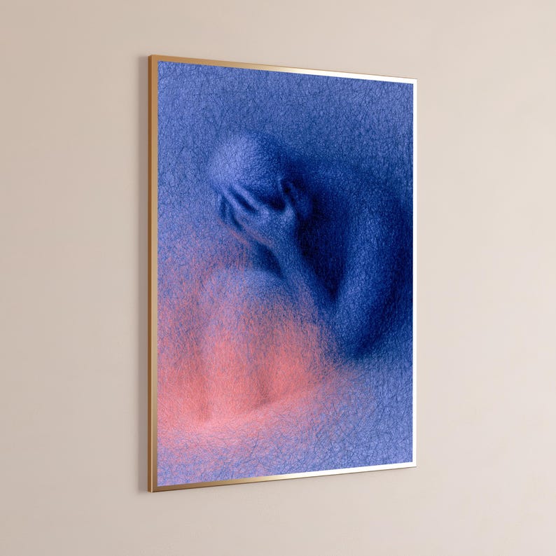 May include: A framed wall art print featuring a textured, blue, scribbled-style illustration of a figure sitting with their head in their hands. The lower portion of the artwork transitions into a soft, glowing pink hue against the blue background.