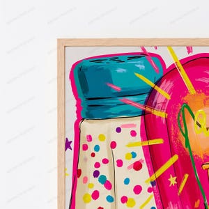 May include: A framed wall art print featuring a stylized illustration of a salt shaker with a teal lid and a cream-colored body covered in multicolored dots, positioned next to a vibrant pink shape with yellow star and line accents.