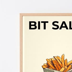 May include: A framed wall art print featuring a light cream background with the black text BIT SAL visible at the top. Below the text is a detailed illustration of a portion of golden-brown french fries served in a paper container.