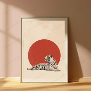 Puede incluir: Una l&aacute;mina de arte mural enmarcada que muestra un tigre blanco con rayas negras tumbado frente a un gran c&iacute;rculo rojo s&oacute;lido. El fondo es de color beige claro con una textura sutil y desgastada. La obra est&aacute; dentro de un marco fino.
