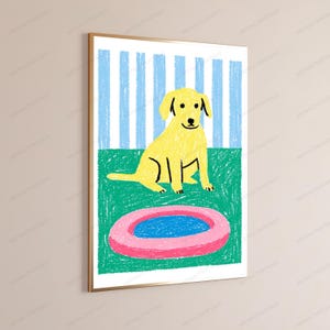 May include: A framed wall art print featuring a yellow dog sitting on a green surface in front of a blue and white striped background. In the foreground, there is a pink circular object with a blue center, rendered in a crayon-like texture.