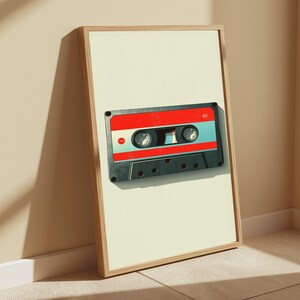 May include: A framed vertical wall art print featuring a graphic illustration of a cassette tape. The tape has a black outer shell, a bright red central band, and a light blue middle section. The number 62 is printed in white on the red band.
