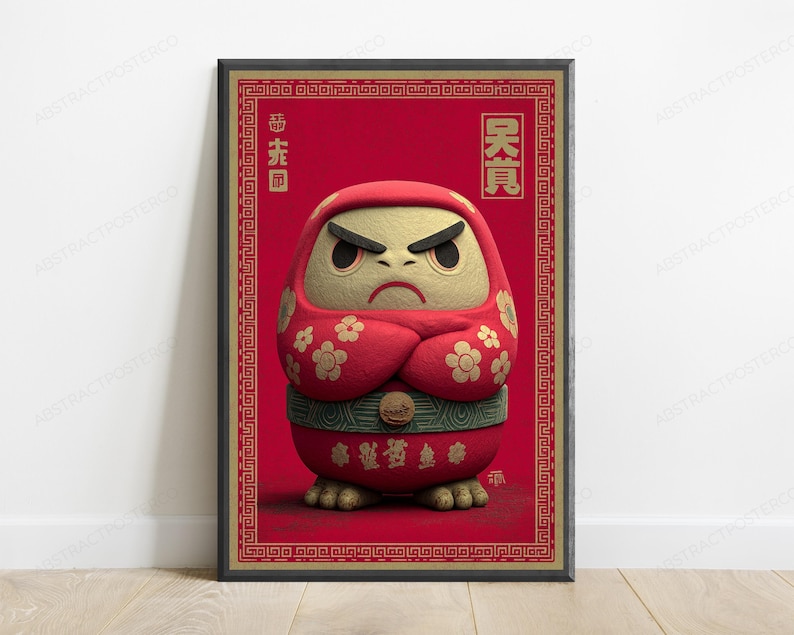 Peut inclure: Une affiche encadr&eacute;e repr&eacute;sentant une poup&eacute;e Daruma rouge stylis&eacute;e avec un visage beige textur&eacute;, des sourcils noirs &eacute;pais et une expression s&eacute;v&egrave;re. La poup&eacute;e porte une robe rouge &agrave; motifs floraux dor&eacute;s, une ceinture verte et des caract&egrave;res asiatiques.