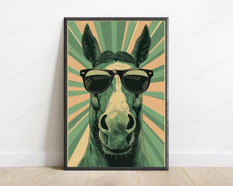 May include: A framed wall art print featuring a stylized illustration of a horse wearing black sunglasses. The horse is centered against a background of alternating light green and tan sunburst rays, creating a graphic, high-contrast visual.