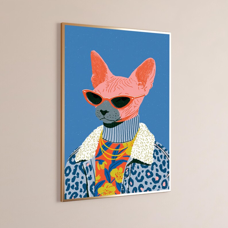 Puede incluir: Una l&aacute;mina de arte mural enmarcada que muestra un gato Sphynx rosa con gafas de sol de ojo de gato rojas, cuello alto gris, cadena dorada y chaqueta con estampado de leopardo azul con cuello de borreguito blanco sobre fondo azul.