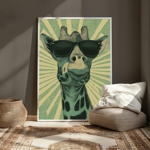 May include: A framed wall art print featuring a stylized illustration of a giraffe wearing black sunglasses. The giraffe is rendered in shades of green and black against a light green background with a radiating sunburst pattern behind the head.