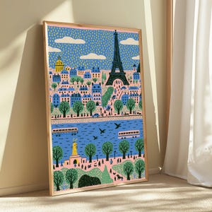 K&ouml;nnte beinhalten: Ein gerahmter Kunstdruck mit einer stilisierten Illustration der Pariser Stadtlandschaft. Die Szene zeigt den Eiffelturm, blaue Geb&auml;ude, gr&uuml;ne B&auml;ume und einen Fluss mit Booten vor einem gepunkteten blauen Himmel und einem zartrosa Boden.