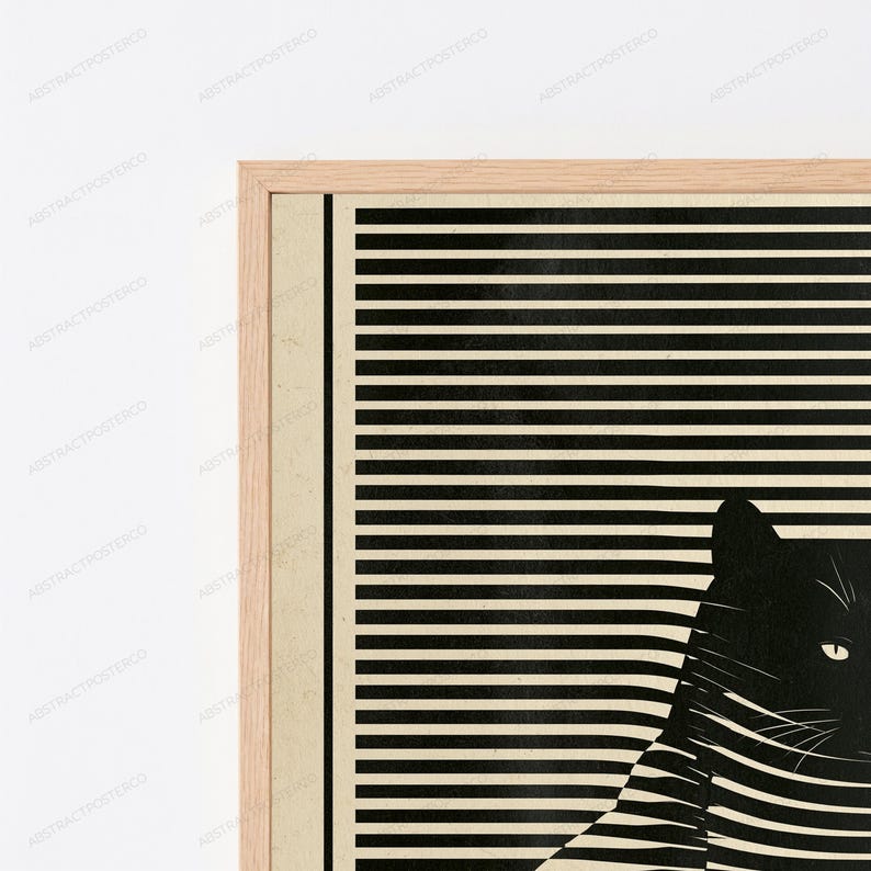 May include: A framed wall art print featuring a black cat silhouette partially obscured by horizontal black and beige stripes. The cat is positioned on the right side, with its eye and whiskers visible against the striped pattern in a light wood frame.