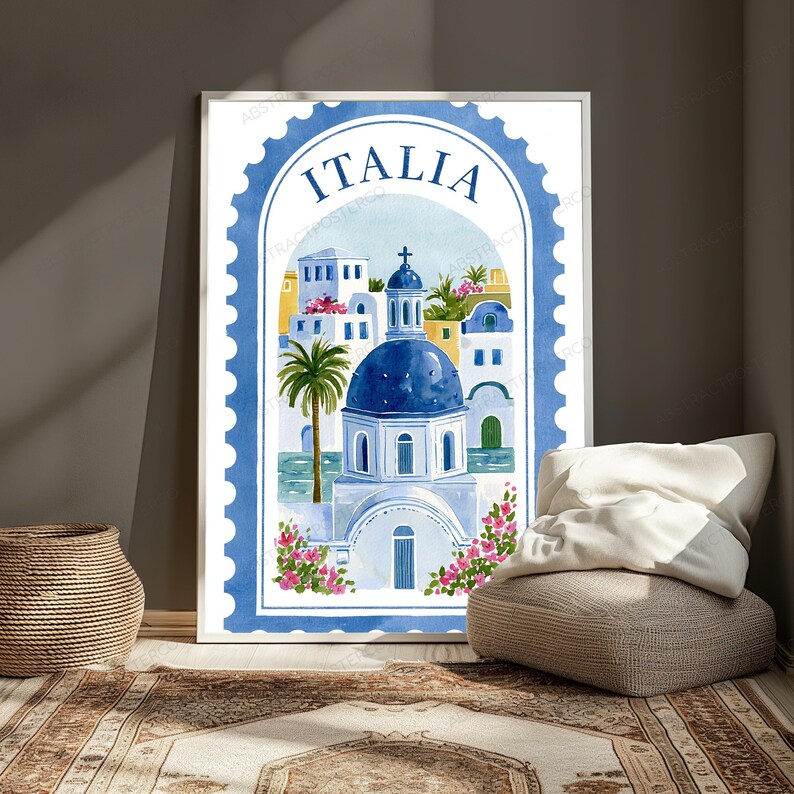 K&ouml;nnte beinhalten: Ein vertikaler, rechteckiger Wandkunstdruck in Form einer Briefmarke mit blauem, gewelltem Rand. Die Illustration zeigt eine Kirche mit blauer Kuppel, wei&szlig;e Geb&auml;ude, eine Palme und rosa Blumen, wobei das Wort ITALIA oben aufgedruckt ist.