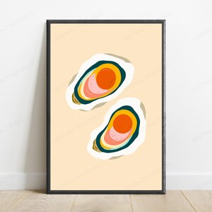 May include: A framed wall art print featuring two stylised oyster illustrations on a light beige background. Each oyster is depicted with concentric layers of white, dark teal, yellow, and pink, centred around a vibrant orange circular core.