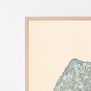 May include: A framed wall art piece featuring a textured, teal-colored fish illustration set against a solid cream-colored background. The artwork is enclosed within a light-toned wooden frame, showcasing a clean, simple design with visible grain.