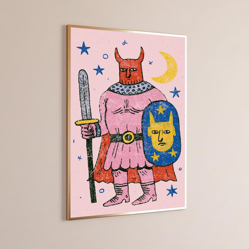 K&ouml;nnte beinhalten: Ein gerahmter Kunstdruck mit einer roten geh&ouml;rnten Figur in rosa R&uuml;stung, die ein graues Schwert und einen blauen Schild mit einem gelben Gesicht und Sternen h&auml;lt. Der Hintergrund ist hellrosa mit blauen Sternen und einer gelben Mondsichel.
