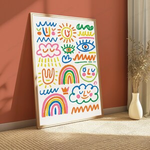 May include: A framed vertical wall art print featuring a white background with colourful hand-drawn doodles including blue waves, an orange sun, green squiggles, pink clouds, eyes, rainbows, a smiling face, and a small crown in various bright colours.