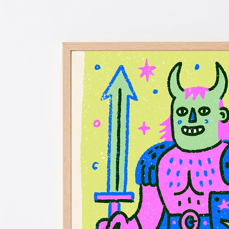 May include: A framed wall art print featuring a stylized illustration of a horned figure in pink and blue armor holding a blue sword. The background is a textured light green with small pink and blue stars and circular shapes throughout.