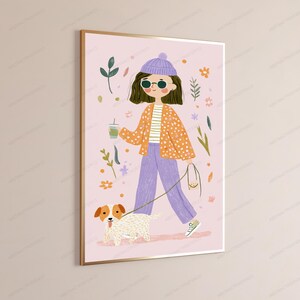 Peut inclure: Une impression d'art mural encadr&eacute;e sur fond rose clair repr&eacute;sentant une illustration stylis&eacute;e d'une personne portant un bonnet violet, des lunettes de soleil, un gilet orange &agrave; pois et un pantalon violet, tenant une boisson et promenant un chien.