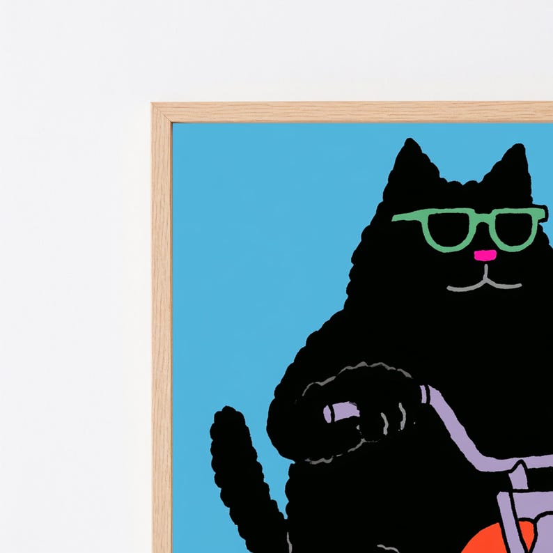 以下が含まれることがあります： ピンクの鼻とライトグリーンのメガネをかけた黒猫が描かれた額装アートプリント。猫はライトパープルのハンドルが付いた自転車に乗っており、背景は明るいブルーです。フレームは明るい色の木材で作られています。