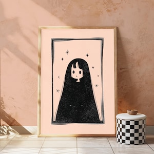 Peut inclure: Une impression d'art encadr&eacute;e repr&eacute;sentant une illustration en noir et blanc d'un personnage aux longs cheveux noirs et au petit visage, centr&eacute; dans un cadre rectangulaire sur fond p&ecirc;che clair, agr&eacute;ment&eacute; de plusieurs petites &eacute;toiles &agrave; quatre branches.